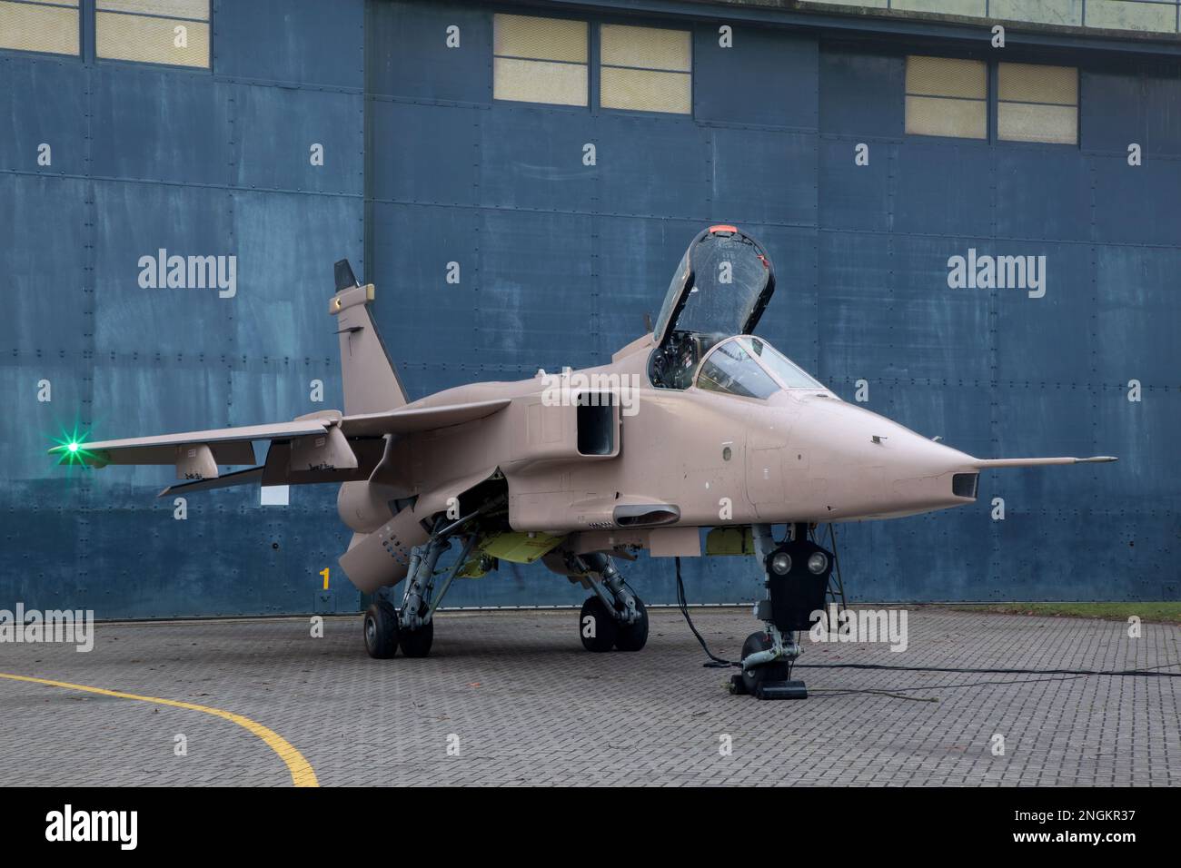Pilota di caccia, RAF, in piedi con Fighter Jet pronto per una missione di combattimento indossando casco volante, tuta e visiera scura con maschera ossigeno Royal Air Force. Foto Stock