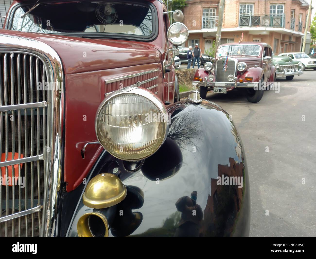 Faro e paraurti dettaglio di un vecchio antico marrone rosso Ford 48 V8 coupé 1935 cinque finestre flathead parcheggiato in strada. Cromi. Spettacolo di auto classica. Foto Stock