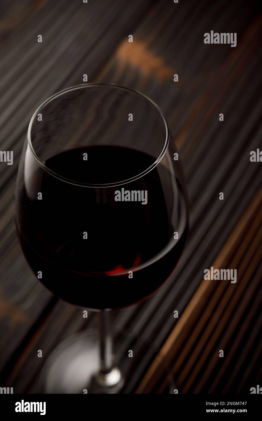 Vino rosso in vetro su tavola di legno Foto Stock