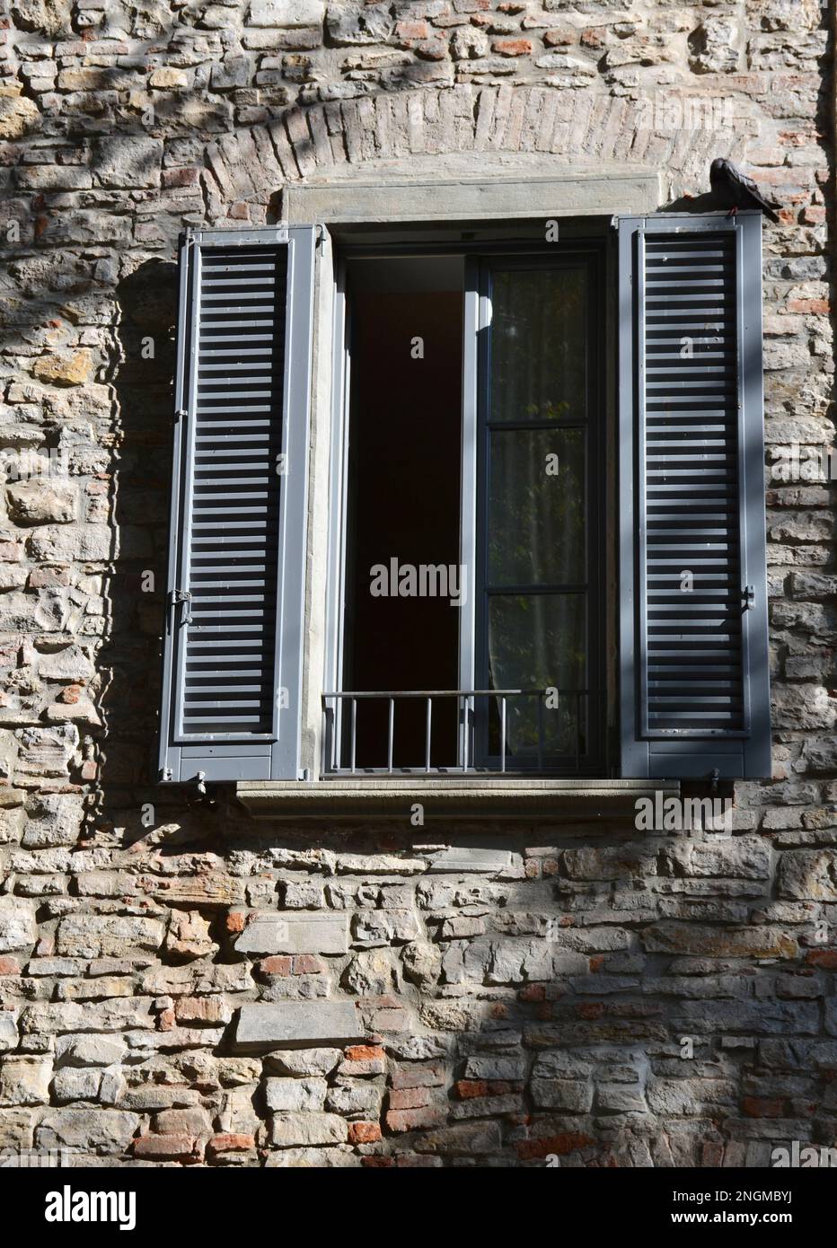 Finestra italiana in una vecchia casa in pietra Foto Stock