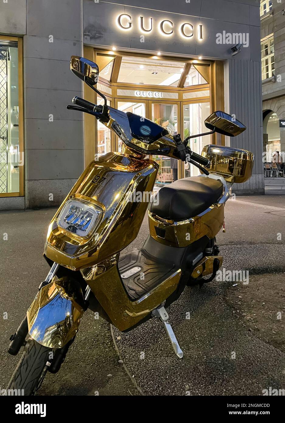 Zurigo, Svizzera - 24 gennaio 2023: Uno scooter placcato oro è parcheggiato sul marciapiede di fronte a un negozio di lusso sulla Bahnhofstrasse di Zurigo. Foto Stock