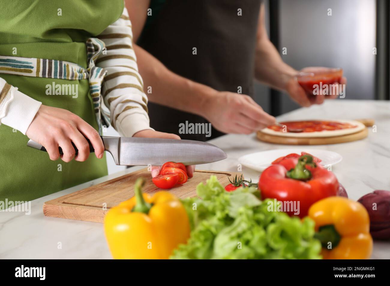 Coppia fare la pizza in cucina, primo piano. Cucinare insieme Foto Stock