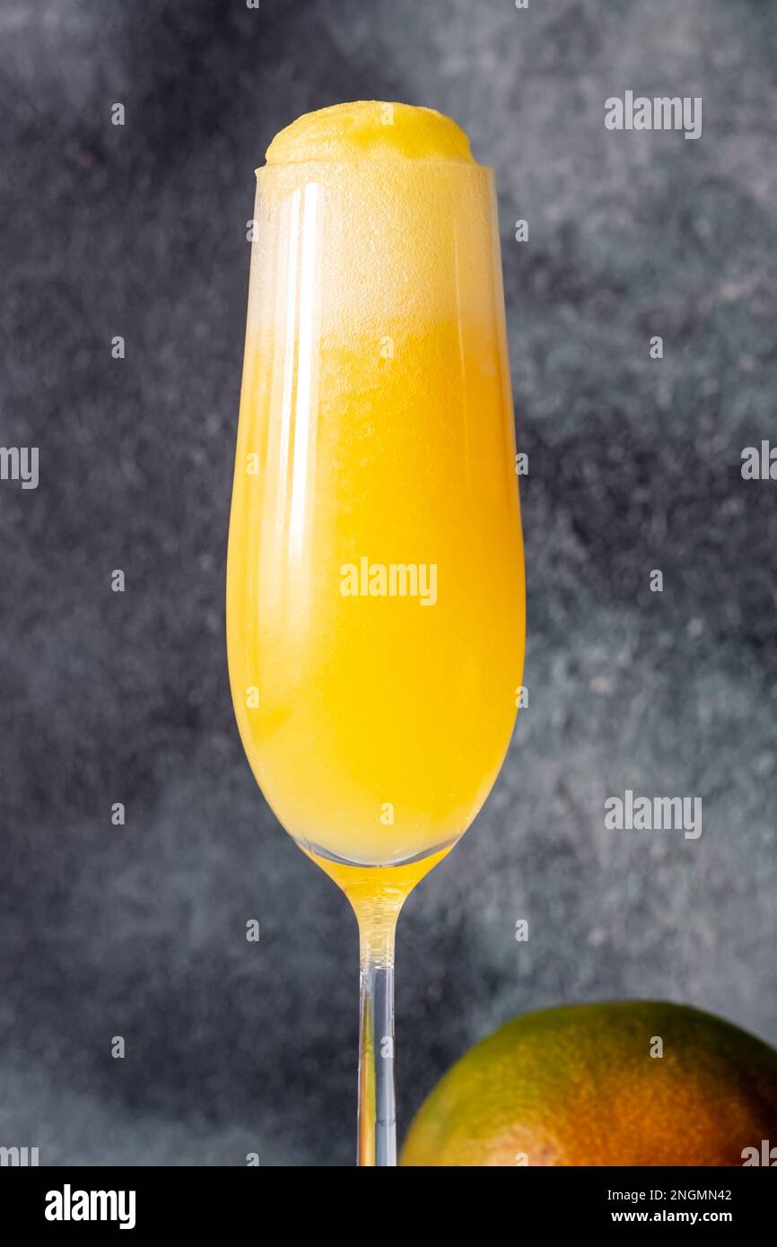 Flauto bicchiere di Mango Mimosa cocktail su sfondo grigio Foto Stock