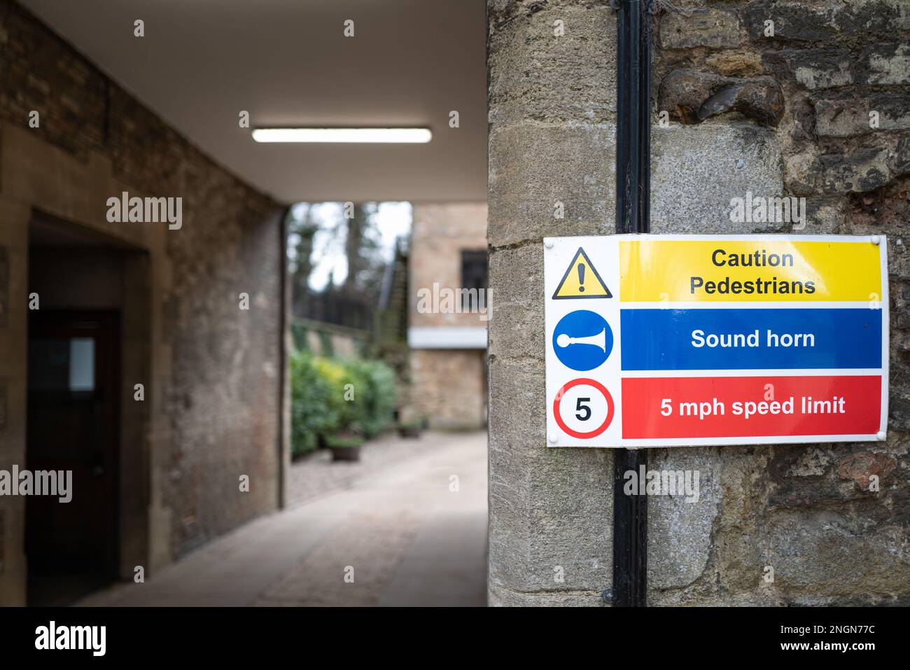 Messa a fuoco poco profonda di un segnale di avvertimento stradale. A causa della distanza ridotta, i veicoli devono prestare attenzione. Visto ad un ingresso ad una scuola pubblica in Inghilterra. Foto Stock