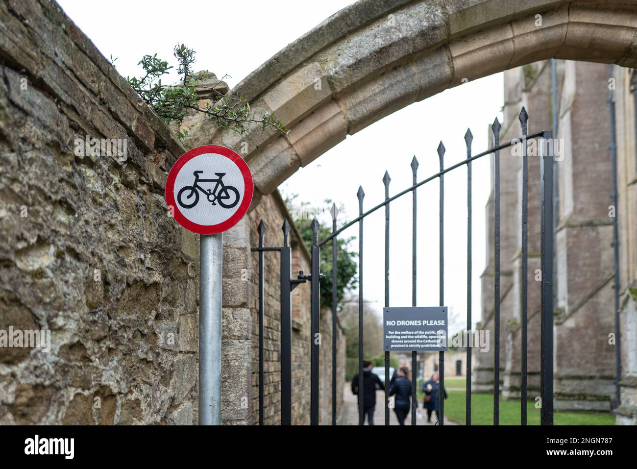 Poco profonda messa a fuoco di un cartello No Cycling all'esterno di una famosa cattedrale inglese. Un cartello sul cancello informa il pubblico di non utilizzare droni nella sono Foto Stock