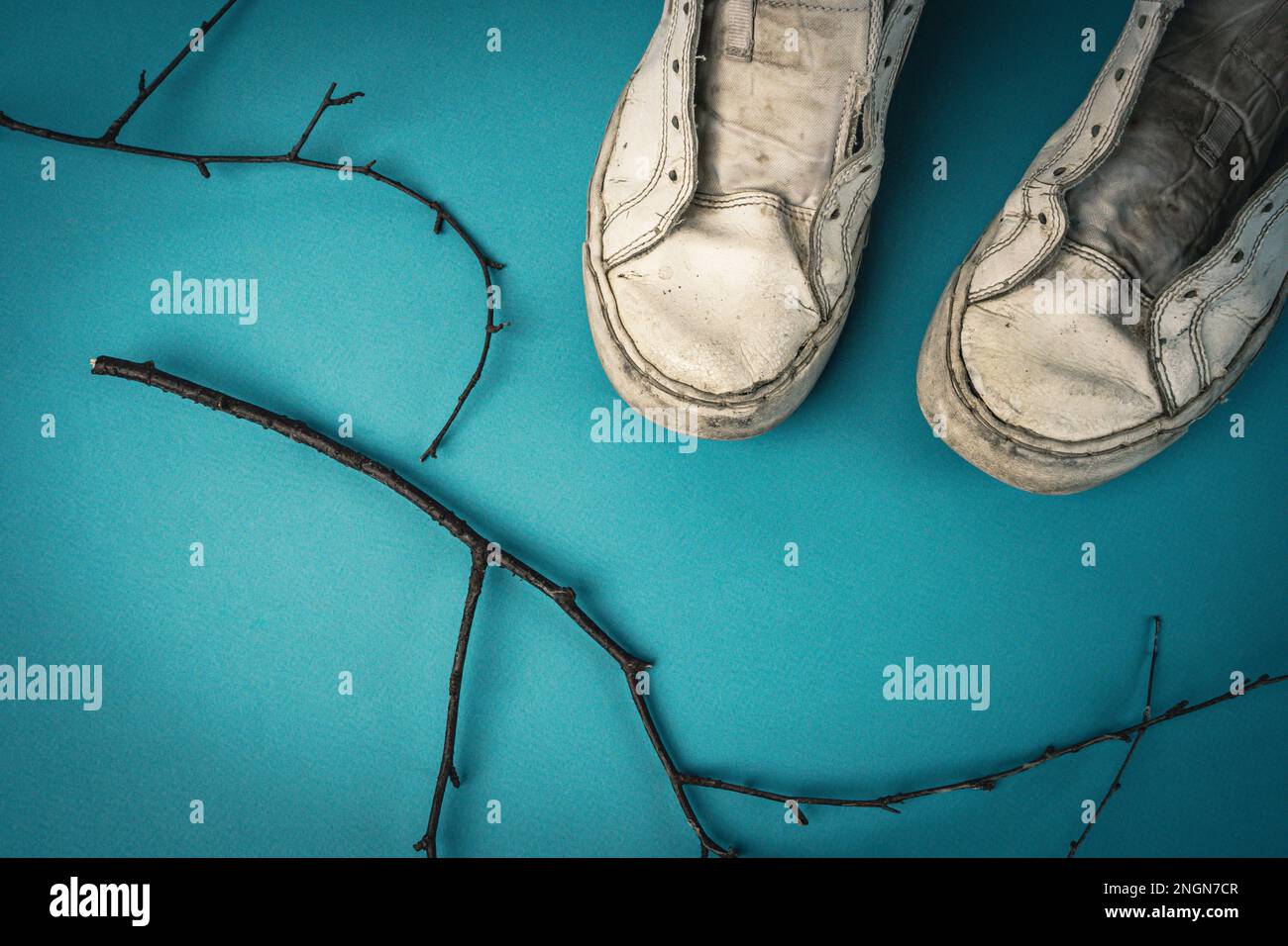 sneaker da donna vecchie senza lacci su sfondo blu. Foto Stock