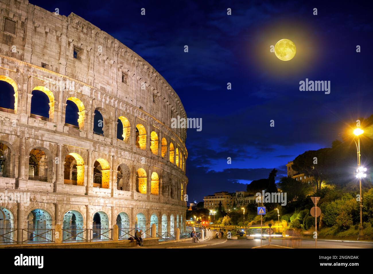 Antico Colosseo romano nel centro della città di Roma contro un cielo blu scuro in una notte estiva illuminata dalla luna. Colosseo Romano, Roma, Italia Foto Stock