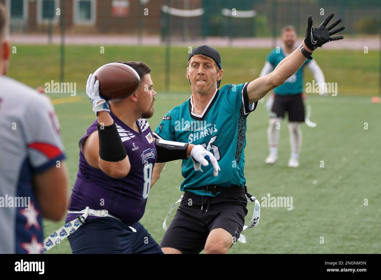 Rusher premeva il Quaterback durante una partita di Flag Football in Galles. Foto Stock