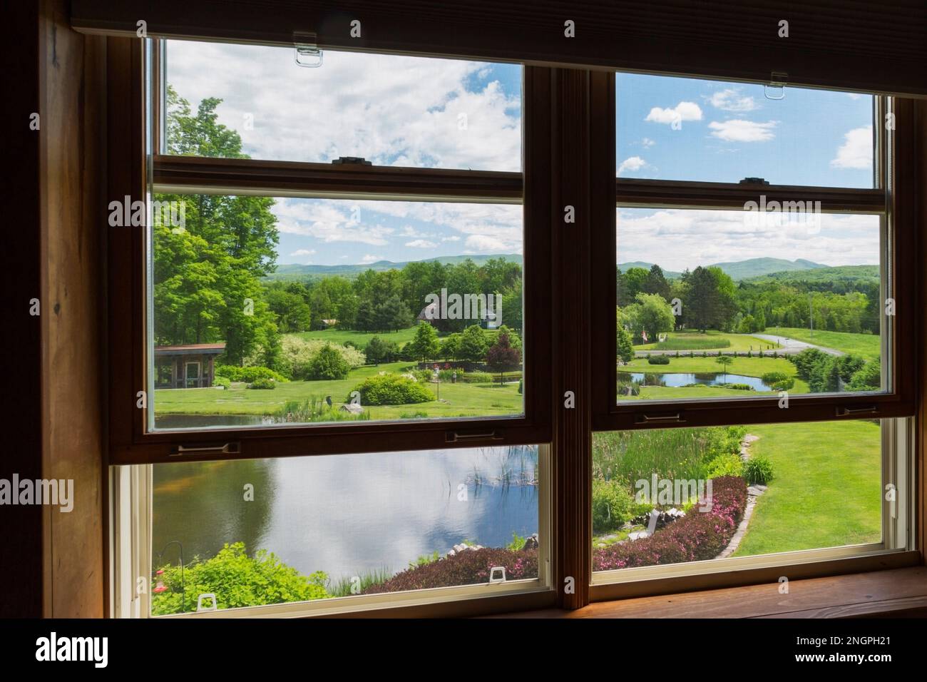 Vista del giardino sul retro con laghetti dalla finestra della camera da letto principale all'interno di una casa di campagna in stile vittoriano contemporaneo degli anni '1990. Foto Stock