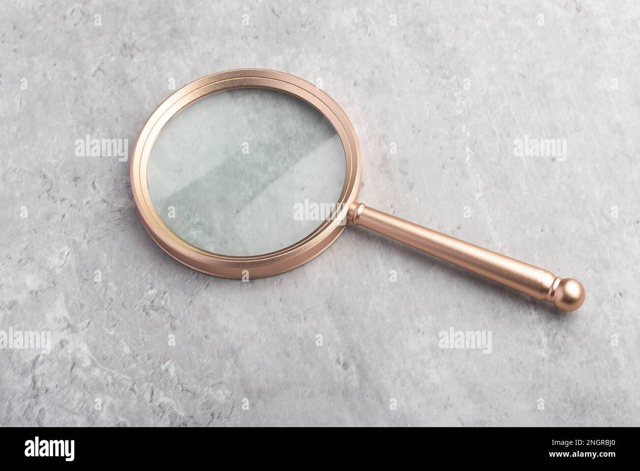 Una lente di ingrandimento su sfondo grigio. Per inserire immagini o testo. Foto Stock
