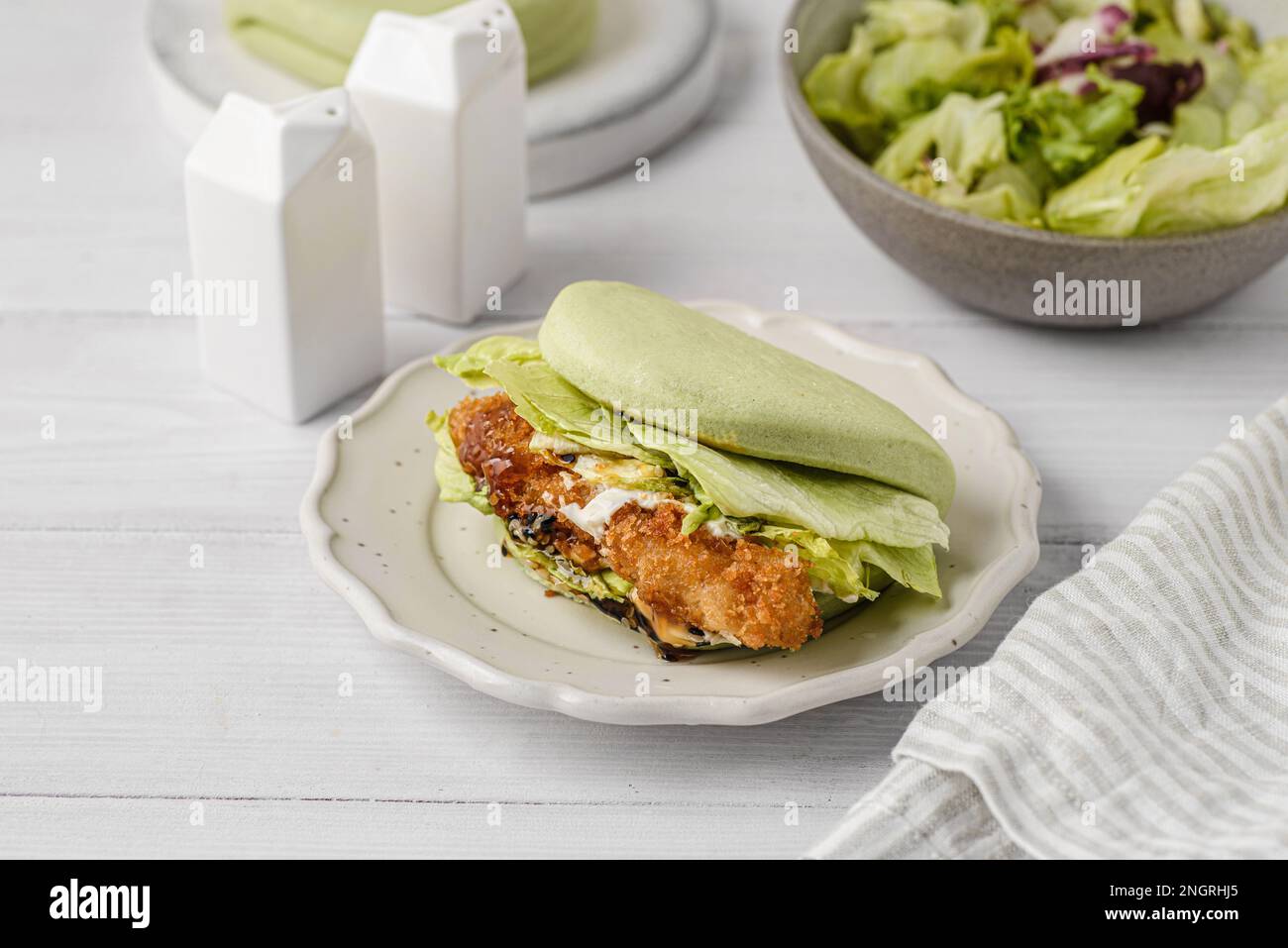 il panino è verde, al vapore, con foglie di verdure e semi di sesamo Foto Stock