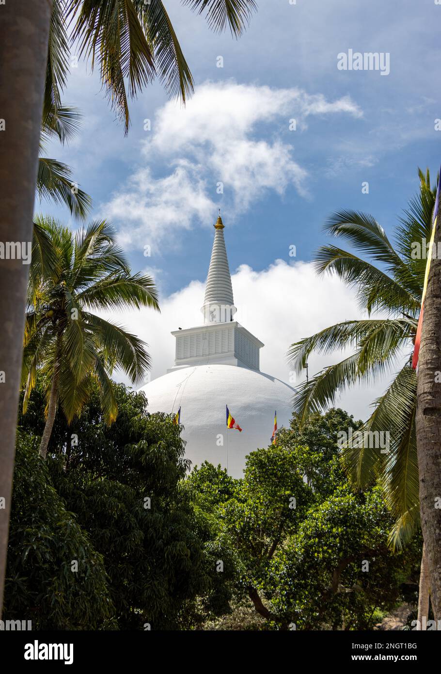 Mihintale stupa in cima alla collina come visto da tra le palme. Ci vuole una lunga salita per raggiungere la cima. Foto Stock