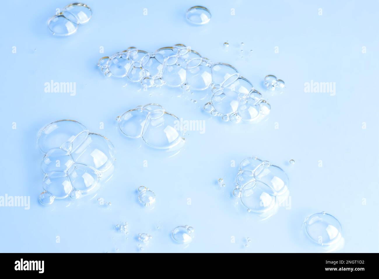 Primo piano macro Aloe vera gel siero struttura cosmetica sfondo blu con bolle. Senza crudeltà. Gel idratante prodotto per la cura della pelle. liquido antibatterico w Foto Stock