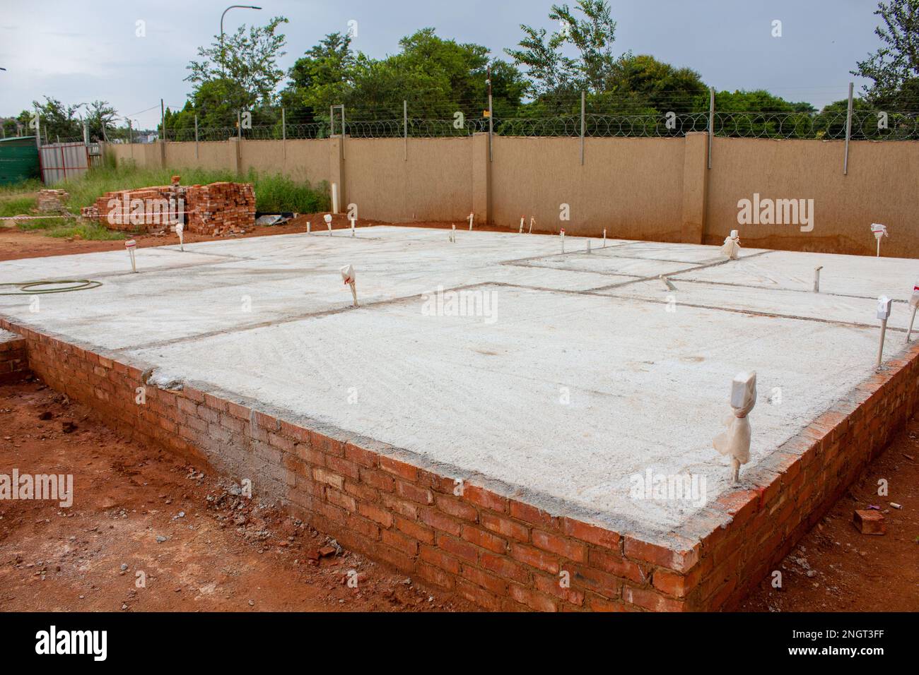 Vista diagonale della fondazione in calcestruzzo per un nuovo edificio in costruzione. Foto Stock