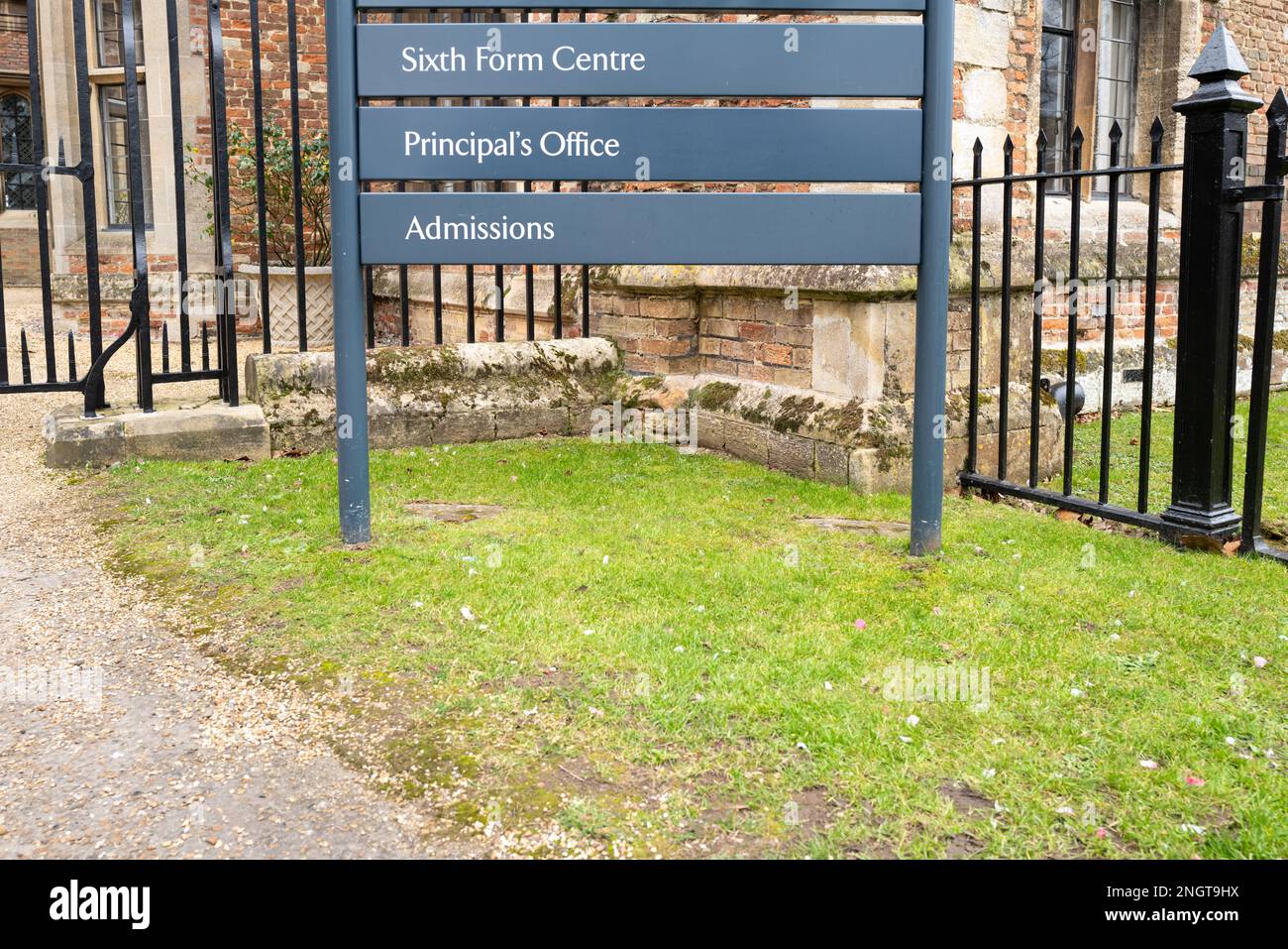 Sesto e il cartello di ammissione della scuola visto all'ingresso dell'edificio della scuola pubblica in Inghilterra. L'edificio, come si può vedere, è di design medievale. Foto Stock