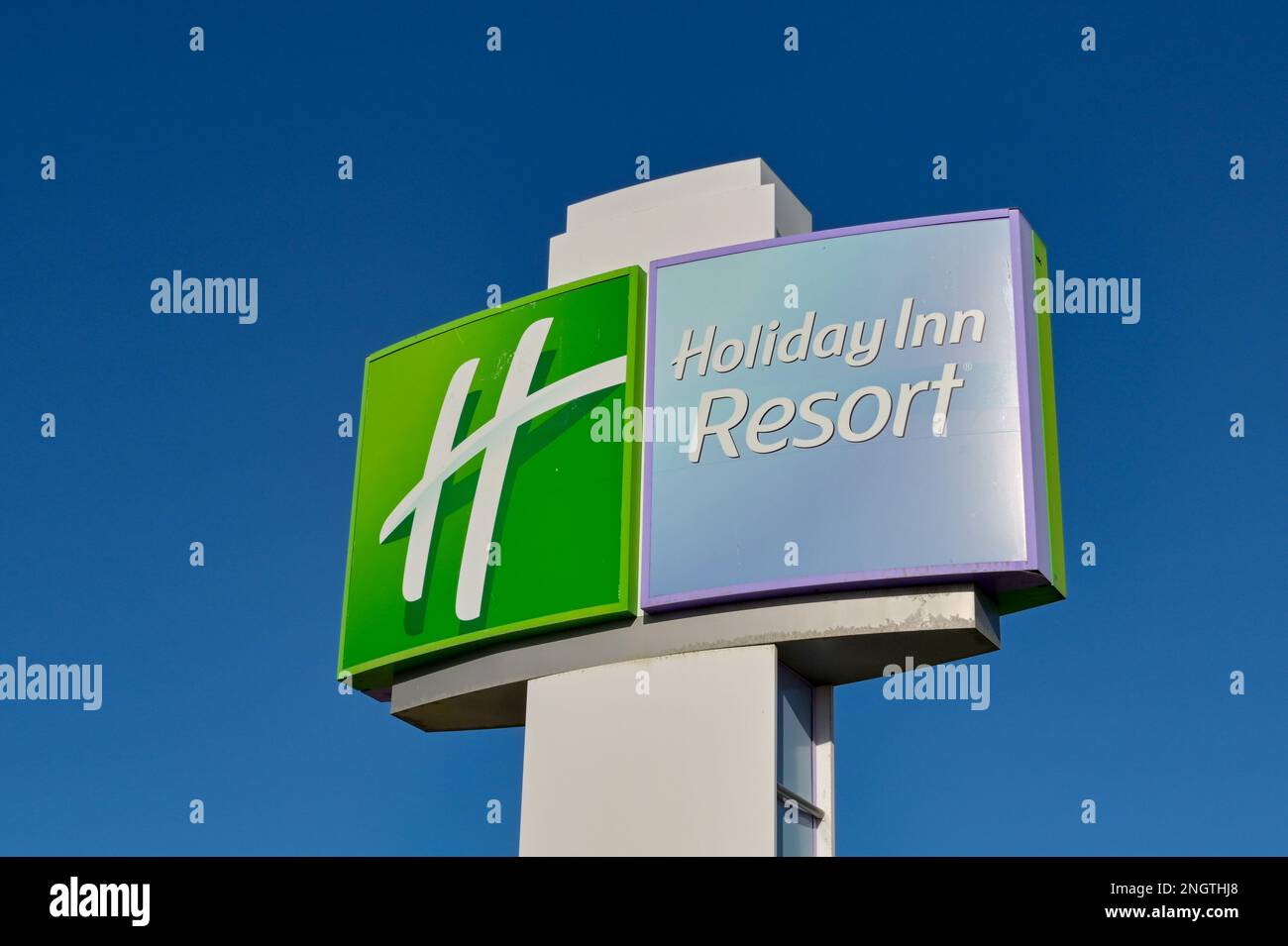 Galveston, Texas - 2023 febbraio: Cartello all'esterno dell'Holiday Inn Beach Resort contro un cielo blu intenso Foto Stock