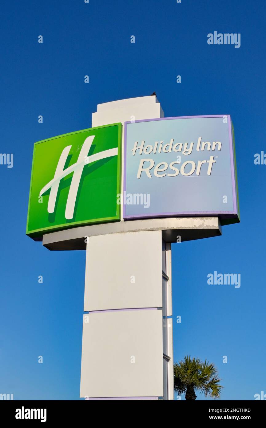 Galveston, Texas - 2023 febbraio: Cartello davanti all'hotel Holiday Inn Beach Resort con un cielo blu intenso Foto Stock