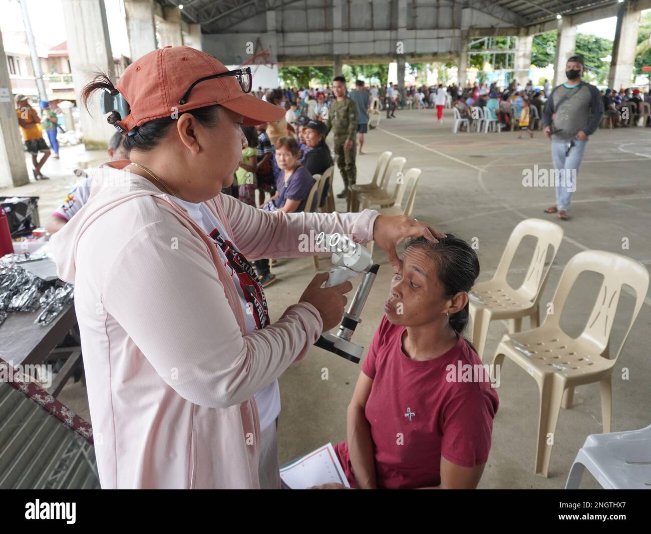Palapag, Filippine. 19th febbraio, 2023. DRA. Maria Theresa Heyrosa, presidente di Mindanao Humanitarian Volunteers for Peace (MHVP) che controlla gli occhi di un paziente nella città di Palapag nella regione del Samar settentrionale durante la missione medica MHVP del 26th in collaborazione con le forze armate delle Filippine. La missione medica gratuita ha lo scopo di portare i servizi pubblici di base nelle aree lacerate dai conflitti nelle Filippine infestate dal gruppo terroristico comunista NPA. (Credit Image: © Sherbien Dacalanio/Alamy Live News) Foto Stock