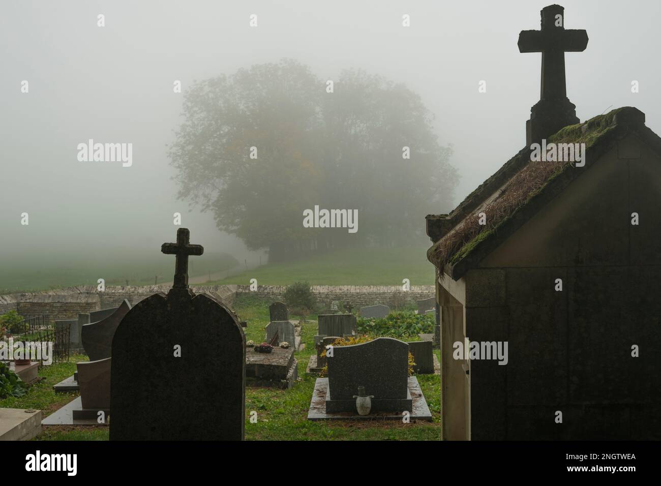 Cimitero spettrale nella campagna della Francia nel tempo nebbiosa Foto Stock