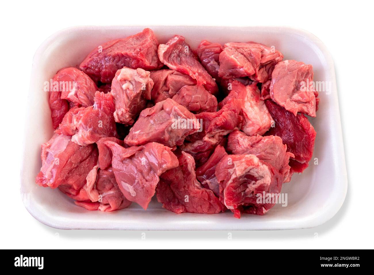 Carne cruda tagliata a dadini per stufato in vassoio di plastica alimentare in vendita al supermercato, isolata su bianco con percorso di ritaglio incluso Foto Stock