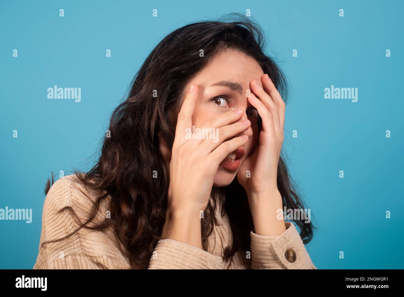 Spaventato scioccato piuttosto millenario studente europeo di sesso femminile coprire il suo volto con le mani Foto Stock