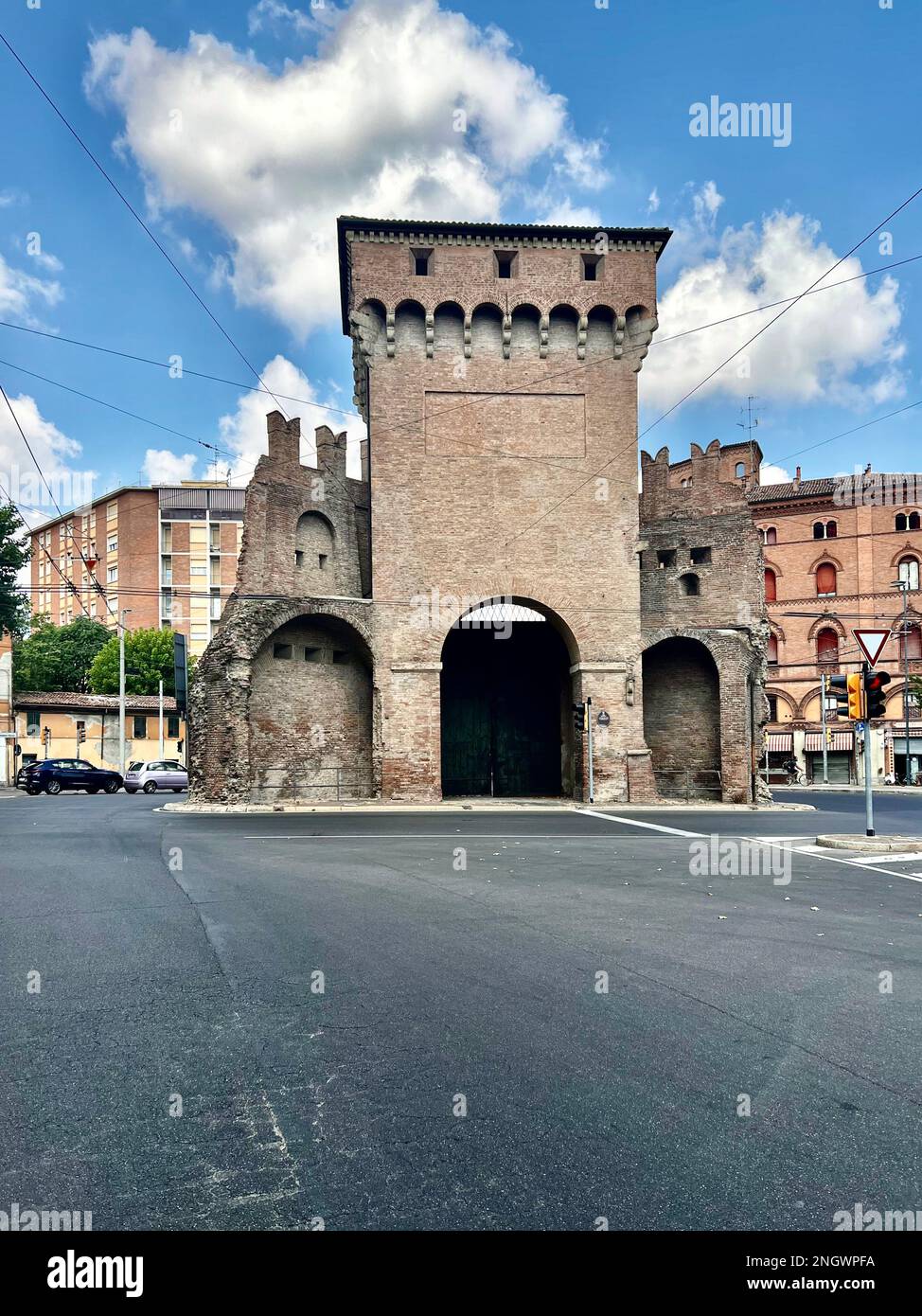 Situata sulla piovana principale dell'antica via Emilia, la porta San Felice del 13th° secolo sorge come un'isola al centro di un vivace incrocio in B Foto Stock