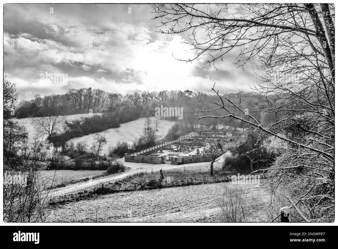 Sottile strato di neve in una giornata nuvolosa - Cemetary sotto la neve | fine couche de neige un jour nuageux - Cimetiere sous la neige Foto Stock