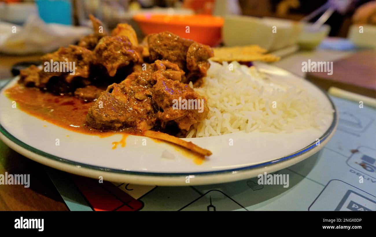 Primo piano di piccante montone di Rogan josh o curry di capra con riso aromatico Basmati o Chawal Foto Stock