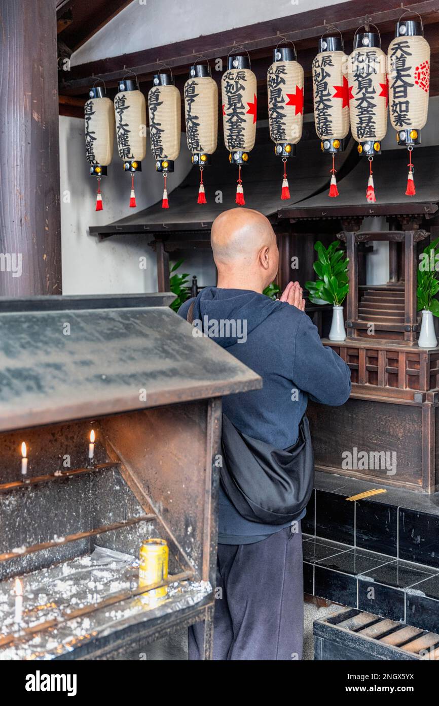 Kyoto Giappone. Uomo che prega al santuario di Yasaka Foto Stock