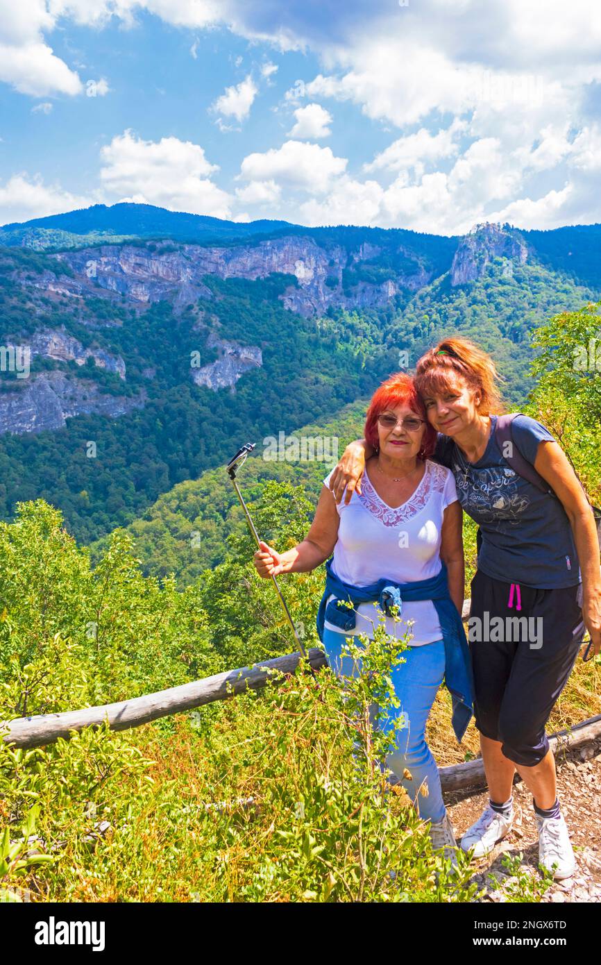 Donna anziana di 71 anni che posa sorridente escursioni con la sua figlia di 52 anni su un percorso forestale in Rhodope Mountains in Bulgaria, agosto 8th 2020 Foto Stock