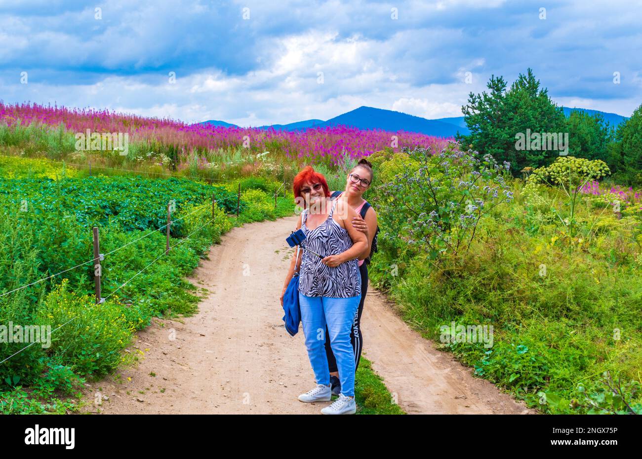 Donna anziana di 71 anni che ha escursioni divertenti con la sua nipote su un percorso sterrato in Rhodope Mountains in Bulgaria, agosto 8th 2020 Foto Stock