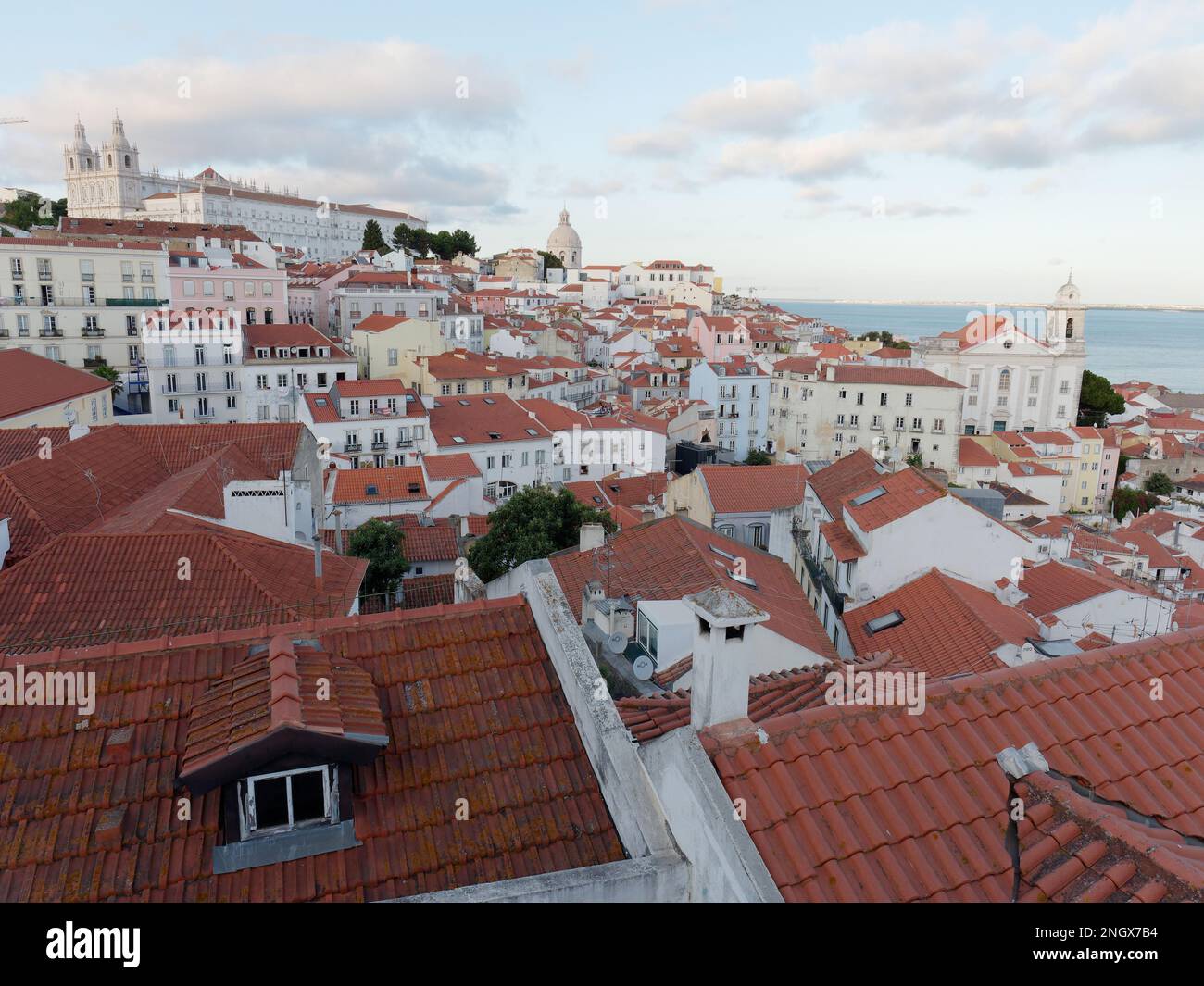 Vista dal punto panoramico Miradouro das Portas do Sol a Lisbona, Portogallo, in una serata estiva. Monastero di São Vicente de Fora top. Fiume Tago a destra Foto Stock