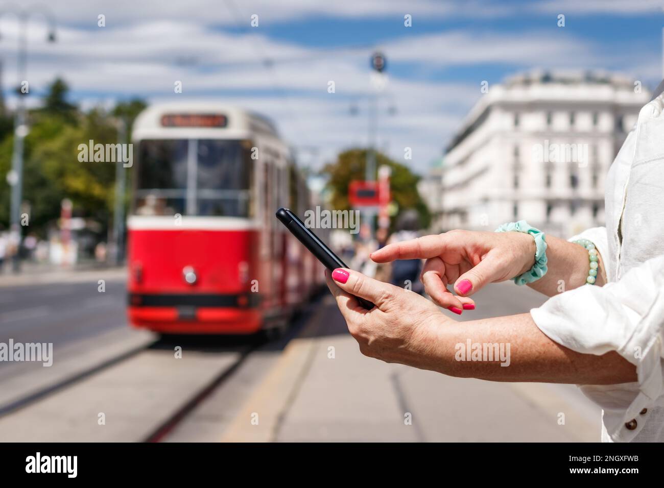 Donna che acquista un biglietto online per il tram con app mobile sul suo smartphone. Trasporto pubblico a Vienna Foto Stock