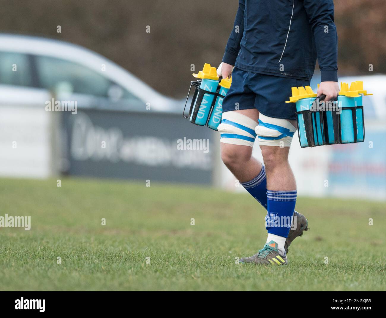 Membro del team di supporto Rugby che trasporta bottiglie d'acqua Ziland Foto Stock
