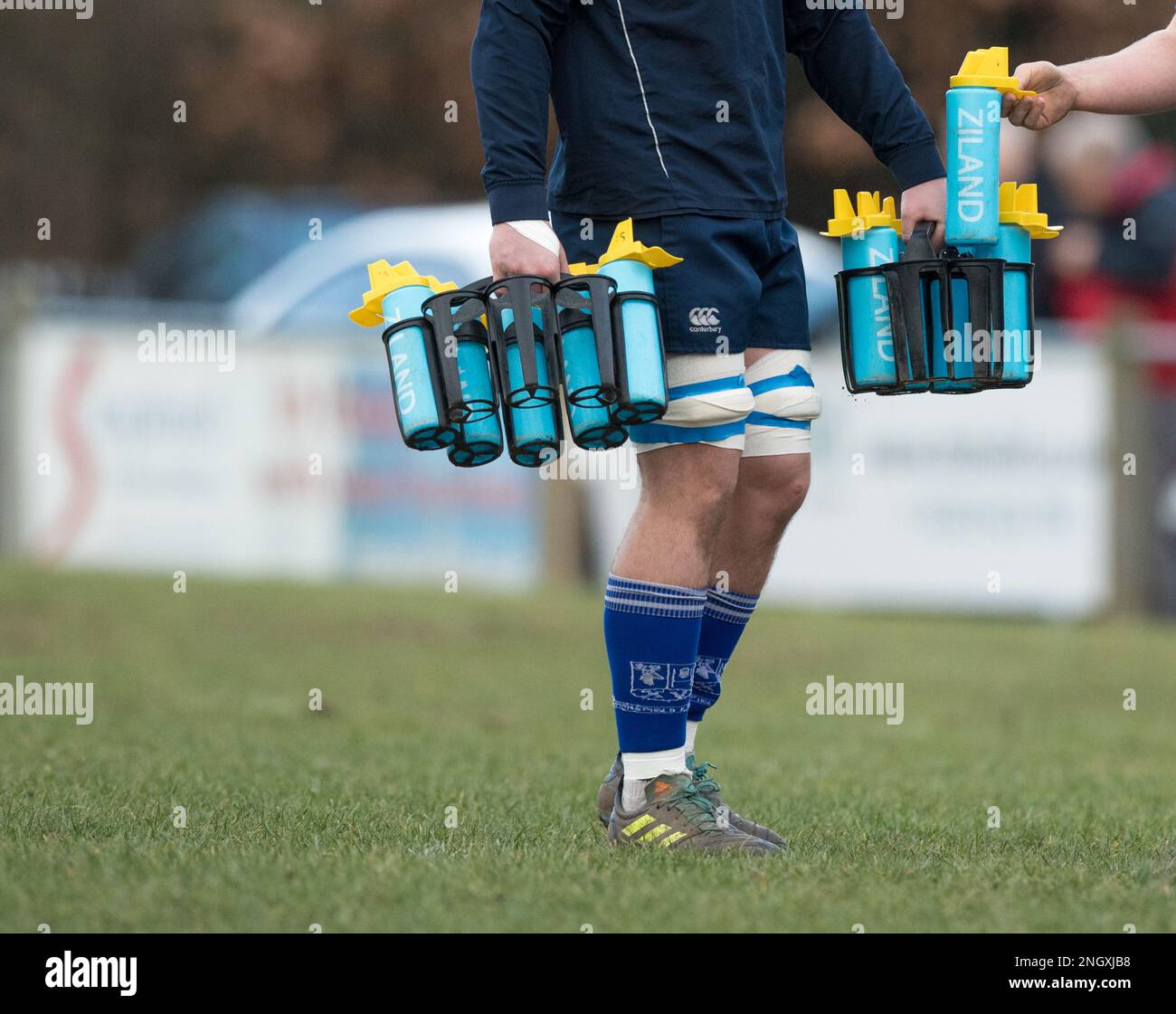 Membro del team di supporto Rugby che trasporta bottiglie d'acqua Ziland Foto Stock