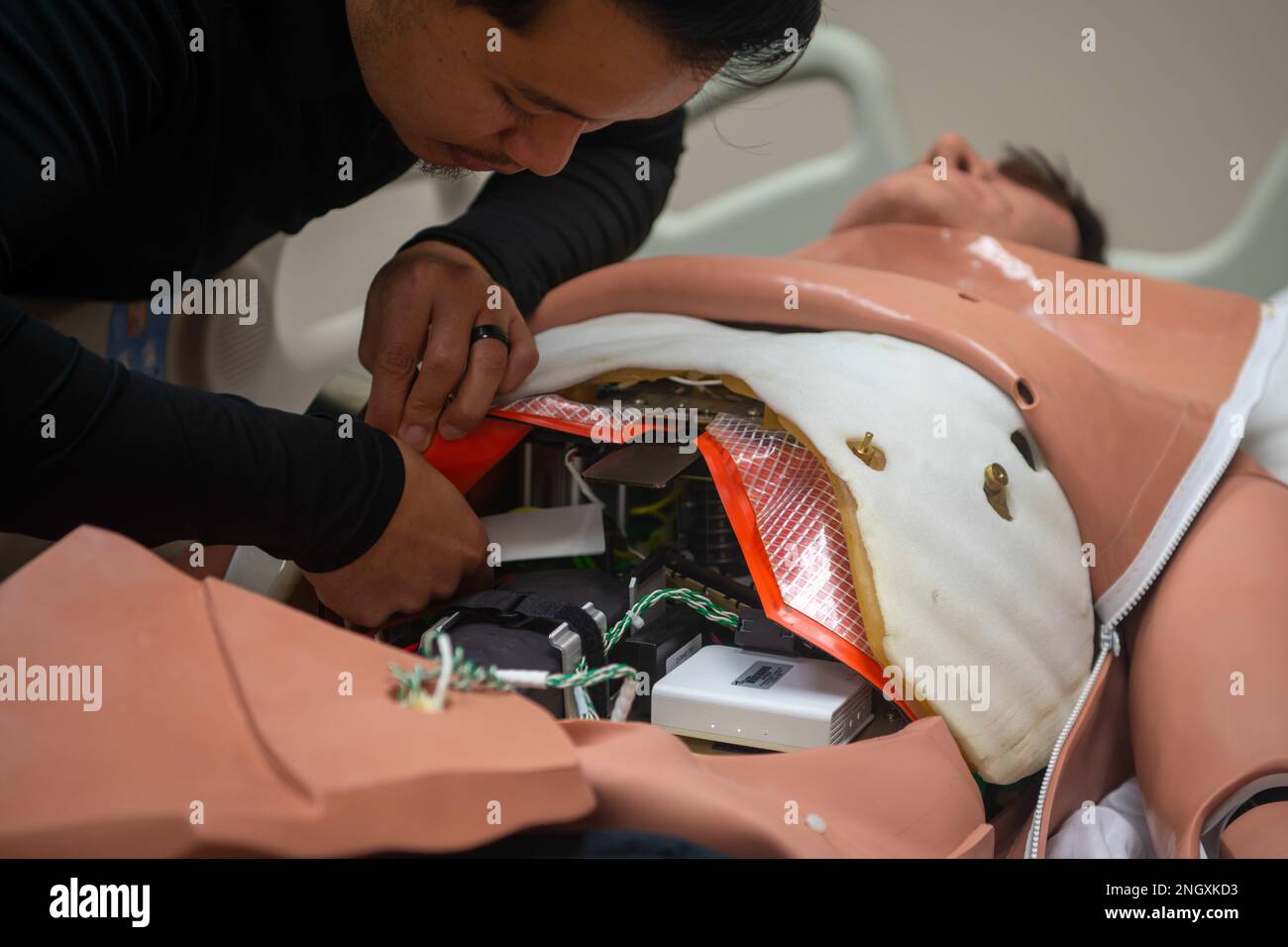 Jethro Sofyan, educatore clinico, mostra la meccanica interna del simulatore CAE Apollo per pazienti adulti 30 novembre 2022, presso la McConnell Air Force base, Kansas. Il CAE Apollo è un simulatore di pazienti adulti ad alta fedeltà, senza cavo e completamente wireless, con un'ampia gamma di caratteristiche vitali quali respirazione, circolazione, sanguinamento, secrezioni di liquidi, minzione e parlato, per offrire una formazione realistica in materia di assistenza sanitaria di emergenza basata su simulazione. Foto Stock