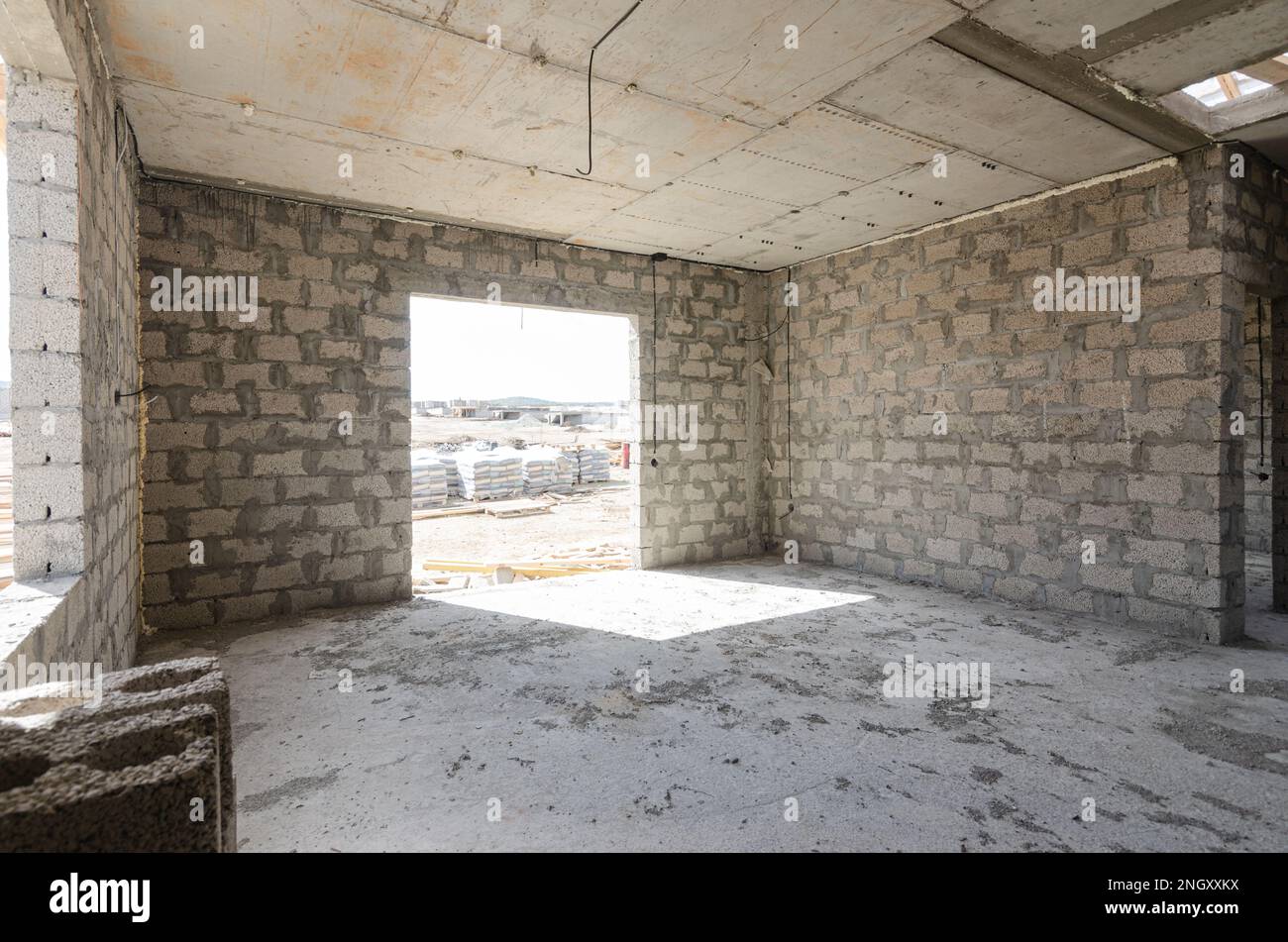 Costruzione di un edificio residenziale individuale, vista di una camera spaziosa con una grande finestra di apertura Foto Stock