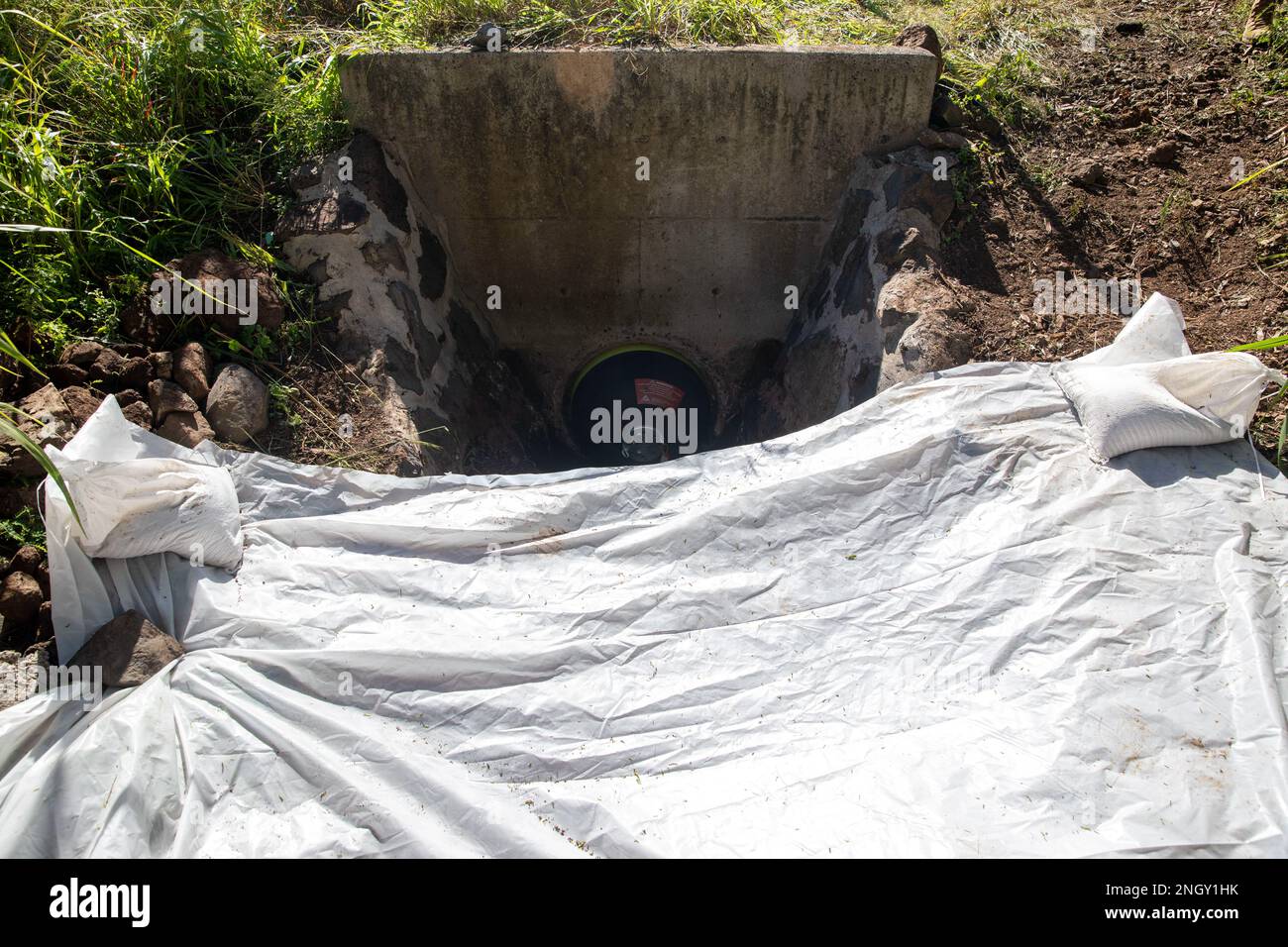 Un tappo a soffietto espandibile viene utilizzato per impedire l'ingresso di materiali contaminati nello scarico delle tempeste presso l'impianto di stoccaggio del combustibile all'ingrosso Red Hill (RHBFSF) di Halawa, Hawaii, 1 dicembre 2022. Il ripristino del sito di fuoriuscita attraverso lo scavo e la rimozione di superfici e materiale contaminati è stato immediatamente iniziato dopo una stima di 1.100 galloni di concentrato di schiuma acquosa formante pellicola (AFFF) versato dal sistema antincendio presso RHBFSF Adit 6 il 29 novembre 2022. JTF-RH è stato istituito dal Dipartimento della Difesa per garantire il derifornimento sicuro e rapido del RHBFSF. Foto Stock