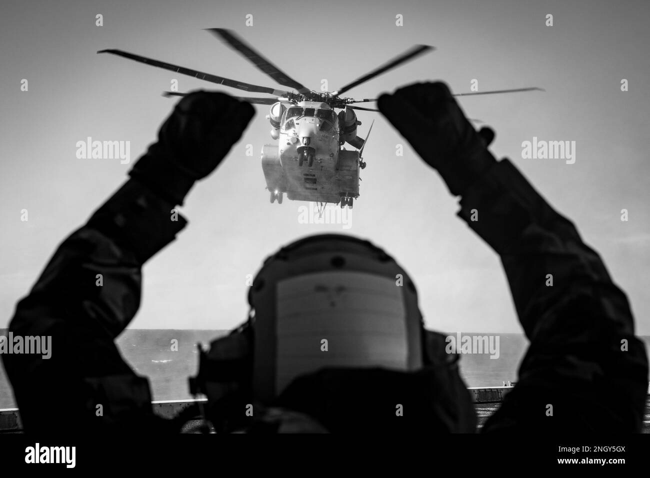 Aviation Support Equipment Technician 2nd Class Luis Soto, assegnato alla nave portuale di trasporto anfibio di classe San Antonio USS Arlington (LPD 24), dirige un elicottero Sikorsky CH-53K King Stallion per atterrare a bordo di Arlington, 14 febbraio 2023. Il King Stallion è un elicottero pesante da carico sottoposto a prove in mare come la prossima evoluzione degli elicotteri della serie CH-53 che sono in servizio dal 1966. (STATI UNITI Foto Navy di Mass Communication Specialist 1st Class John Bellino (questa foto è stata convertita da colore a bianco e nero per scopi creativi). Foto Stock Aviation Support Equipment Technician 2nd Class Luis Soto, assegnato alla nave portuale di trasporto anfibio di classe San Antonio USS Arlington (LPD 24), dirige un elicottero Sikorsky CH-53K King Stallion per atterrare a bordo di Arlington, 14 febbraio 2023. Il King Stallion è un elicottero pesante da carico sottoposto a prove in mare come la prossima evoluzione degli elicotteri della serie CH-53 che sono in servizio dal 1966. (STATI UNITI Foto Navy di Mass Communication Specialist 1st Class John Bellino (questa foto è stata convertita da colore a bianco e nero per scopi creativi). Foto Stock