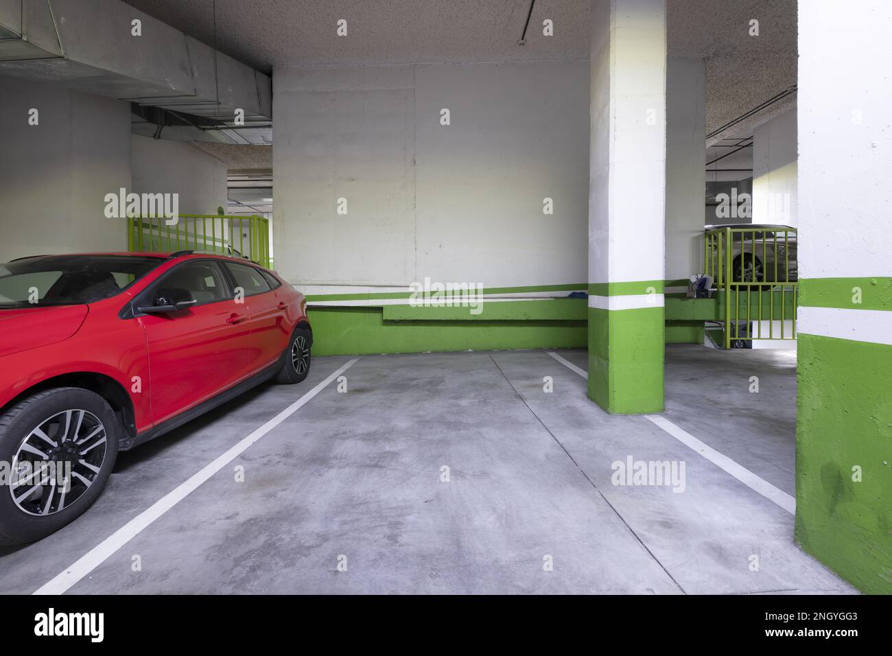 Piano terra di un edificio con garage e veicoli parcheggiati Foto Stock