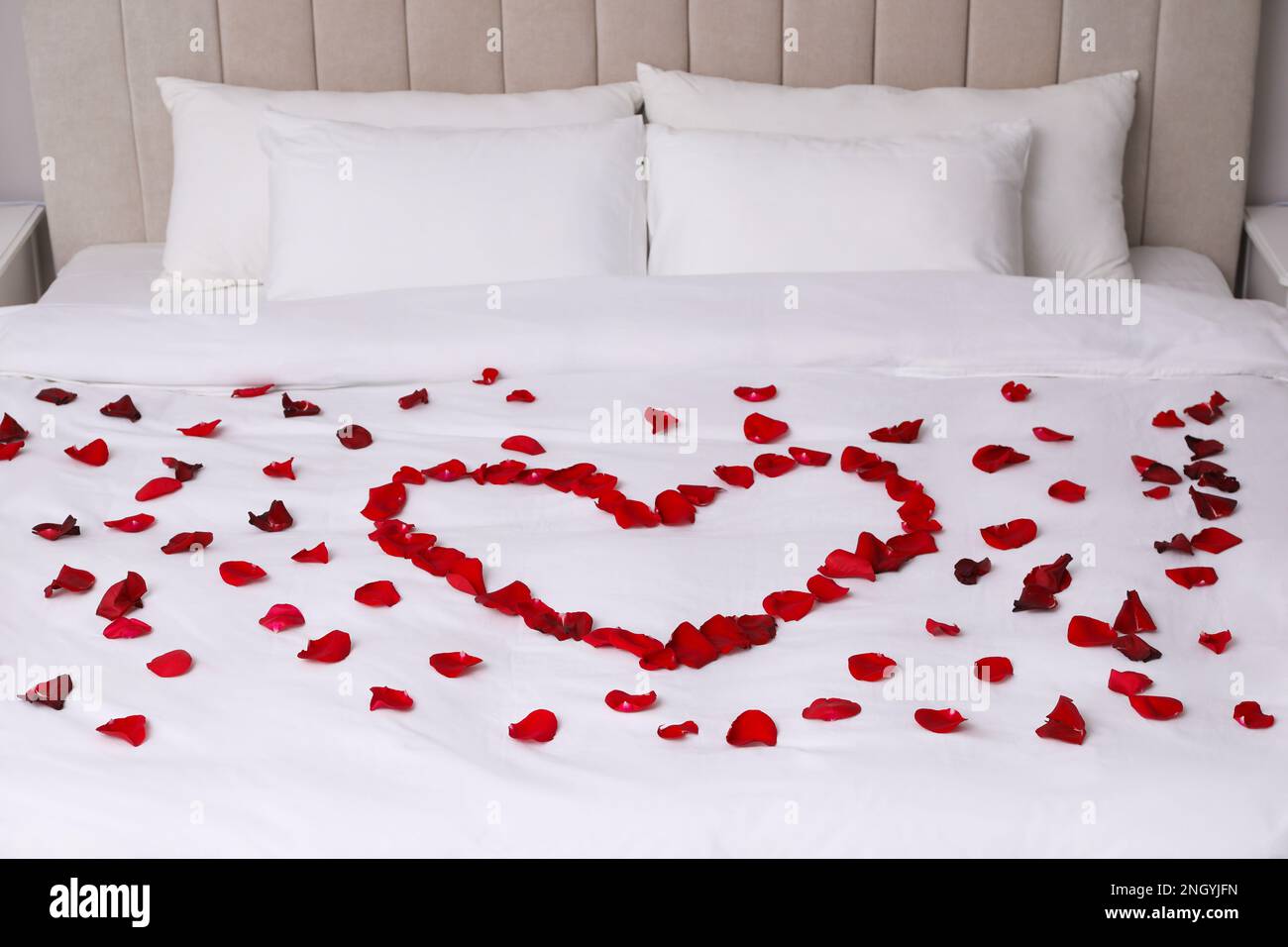Cuore di petali di colore rosso sul letto, close up Foto stock - Alamy
