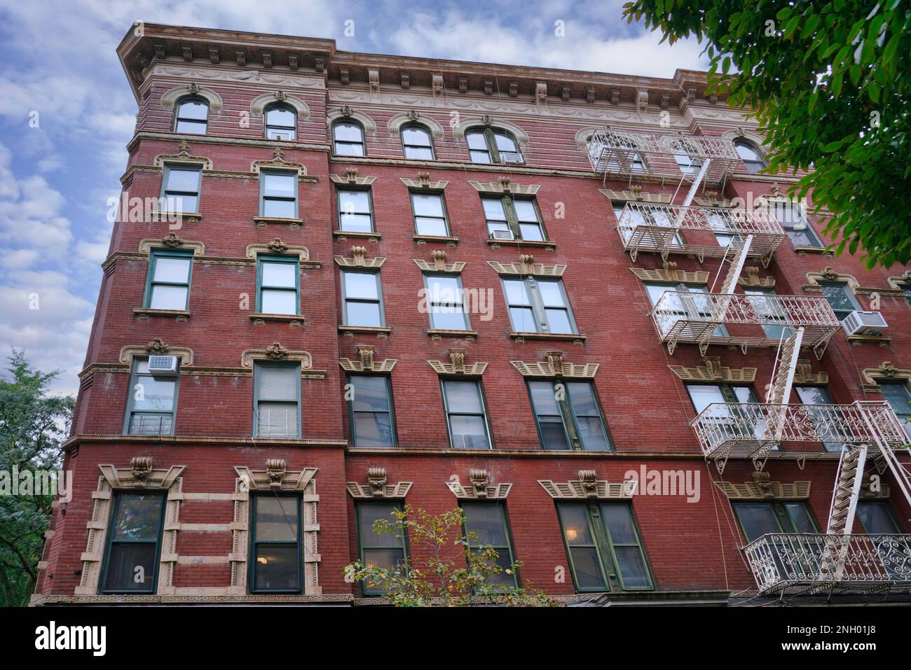 Edificio di appartamenti in vecchio stile di New York con sculture decorative in pietra intorno alle finestre Foto Stock