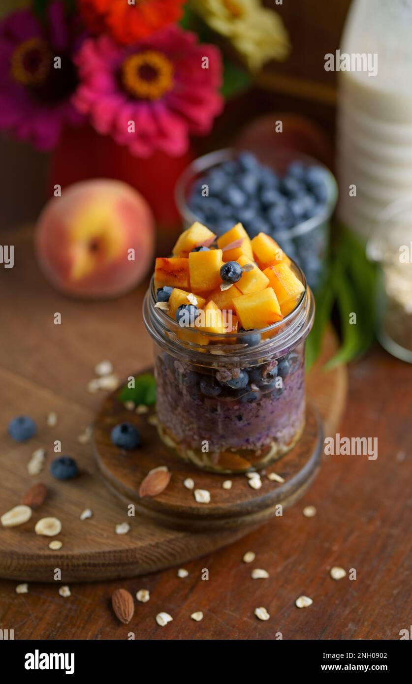 Prima colazione yogurt parfait granola con pesca e mirtillo in un vasetto, cibo sano Foto Stock