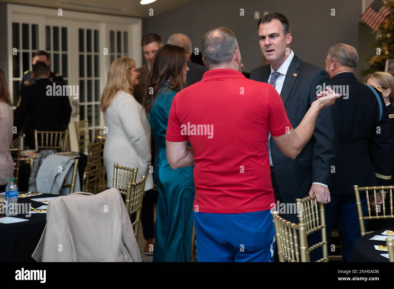 Gov. Kevin Stitt (a destra) parla ai partecipanti alla cerimonia Gold Star Family Dinner and Tree Lighting tenutasi al Phillips Pavilion presso l'Oklahoma Governor's Mansion di Oklahoma City, il 3 dicembre 2022. La cerimonia Gold Star Family Dinner and Tree Lighting si è tenuta per onorare i 20 membri della Guardia Nazionale dell'Oklahoma che sono morti all'estero dal 11 settembre 2001. (Foto della Guardia Nazionale dell'esercito dell'Oklahoma di SPC. Caleb Stone) Foto Stock