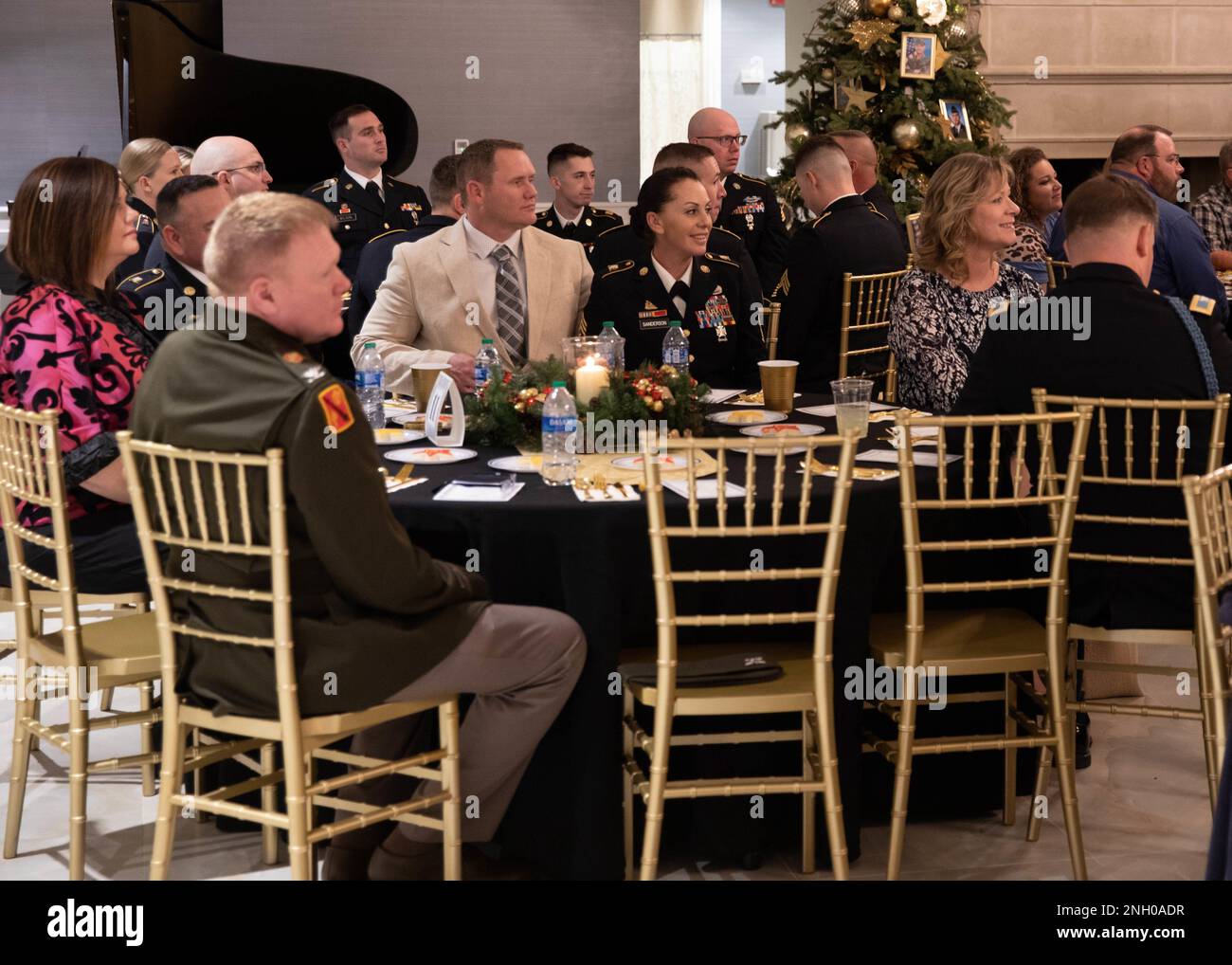 I membri della famiglia e i membri della direzione nazionale dell'Oklahoma ascoltano le osservazioni date alla cerimonia dell'illuminazione dell'albero e della cena della famiglia della stella d'oro tenuta al padiglione di Phillips alla residenza del regolatore dell'Oklahoma a città di Oklahoma, 3 dicembre 2022. La cerimonia si è tenuta per onorare 20 membri della Oklahoma National Guardsmen che sono morti all'estero dal 11 settembre 2001. (Foto della Guardia Nazionale dell'esercito dell'Oklahoma di SPC. Caleb Stone) Foto Stock