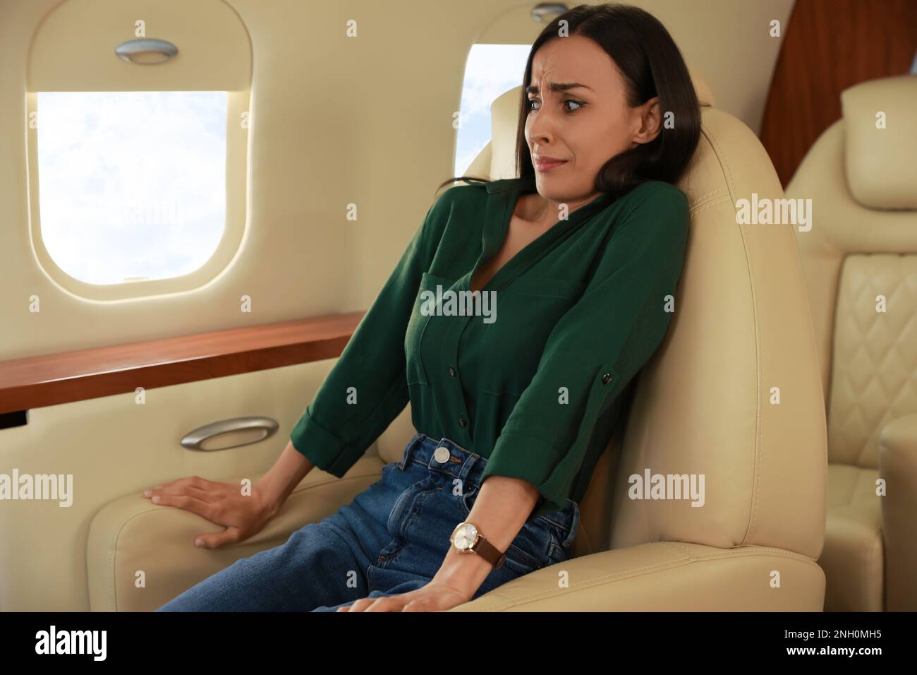Giovane donna nervosa che soffre di avofobia in aereo Foto Stock