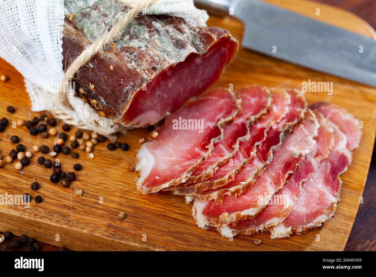 Filetto di maiale a fette con spezie su sfondo di legno Foto Stock Filetto di maiale a fette con spezie su sfondo di legno Foto Stock