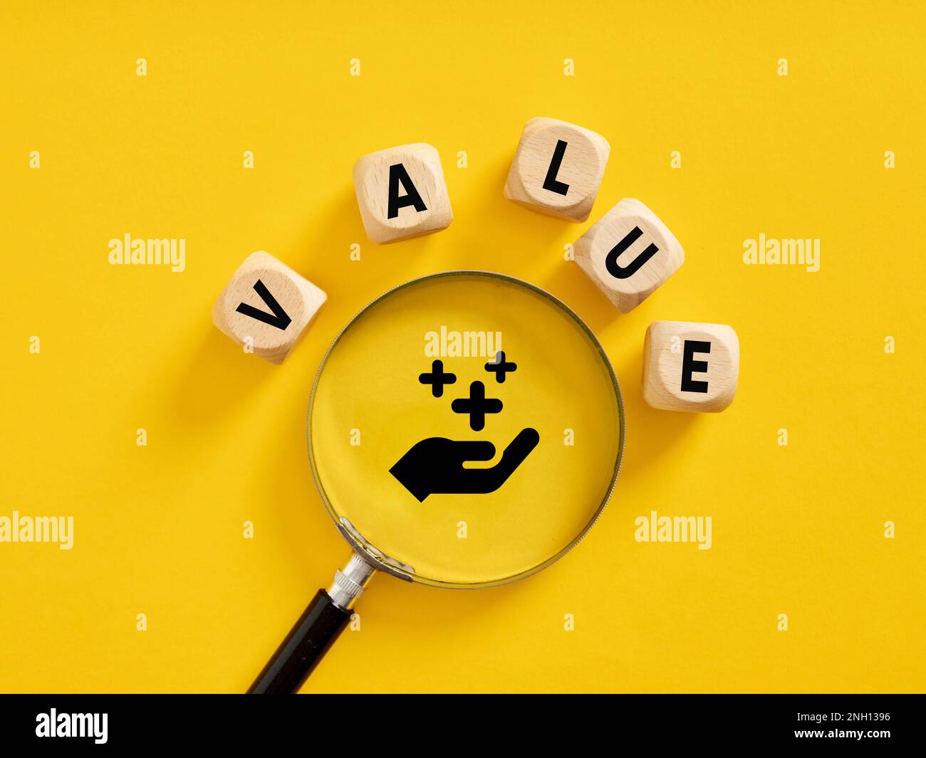 Valore aggiunto. Valore delle risorse aziendali o qualità del servizio. Il valore della parola su cubi di legno con lente di ingrandimento. Foto Stock