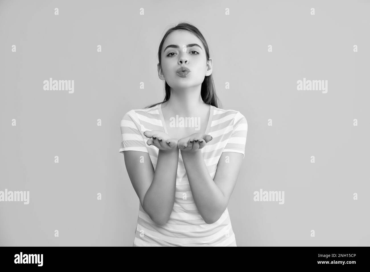 ragazza giovane in estate a righe su sfondo giallo. baciare Foto Stock