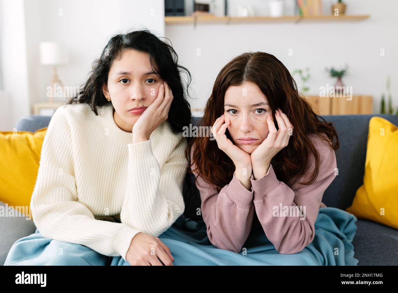 Due giovani amiche che si annoiavano guardando film o televisione Foto Stock